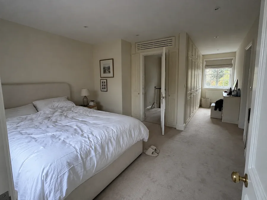 Bedroom with the grille set into the top of the fitted wardrobe beside the door