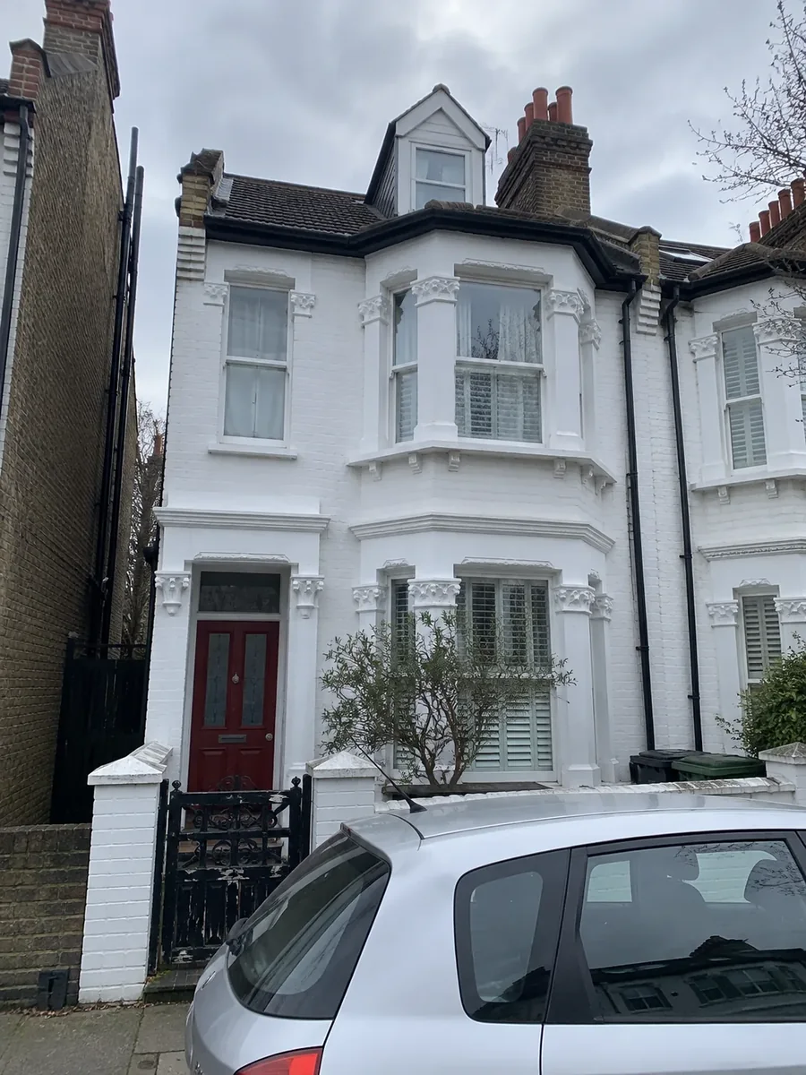 White-painted terraced house with a bay window