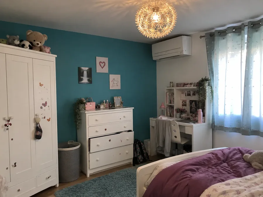 Child's room with a turquoise wall and the air conditioning fitted