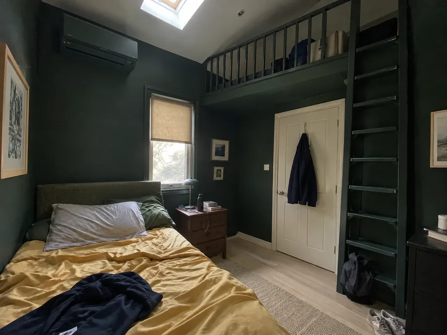 Mezzanine bedroom with dark green walls and the air conditioning fitted