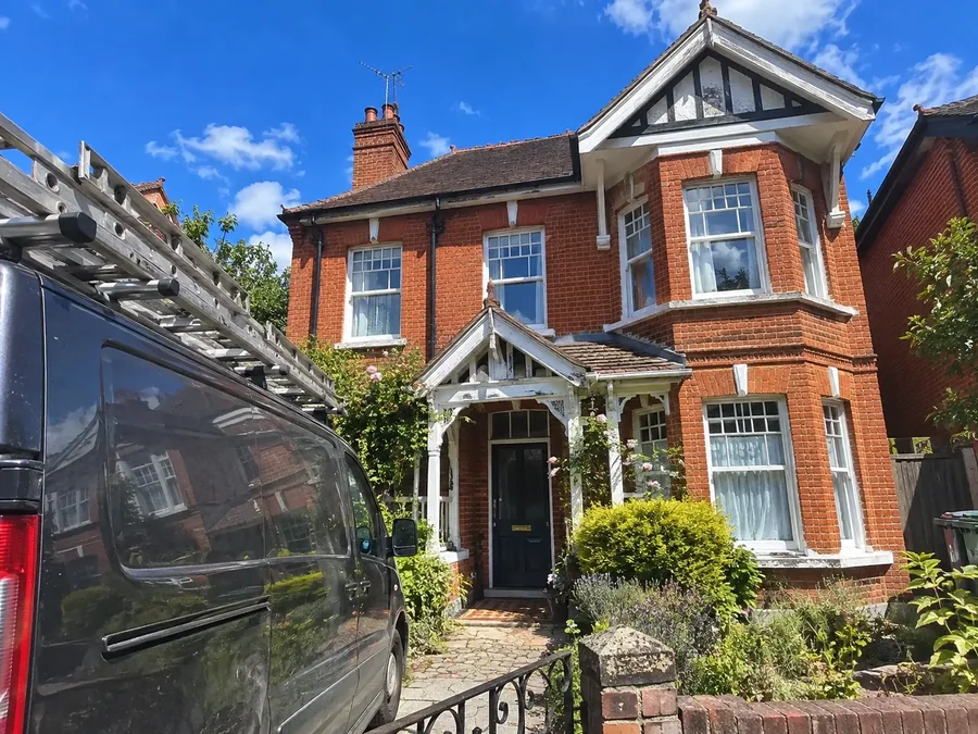 Edwardian house with a white timber porch, our van parked at the gate with ladders on the roof