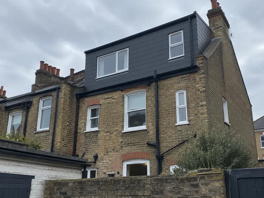 Rear of a London terrace with a dark-clad loft extension above the original brickwork