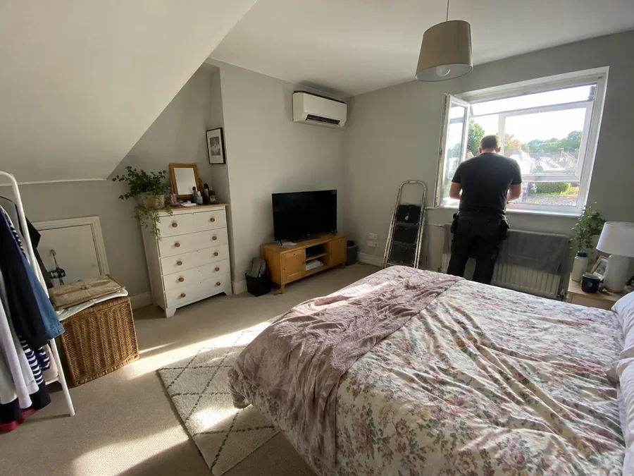 Bedroom with the unit fitted and an engineer finishing at the window