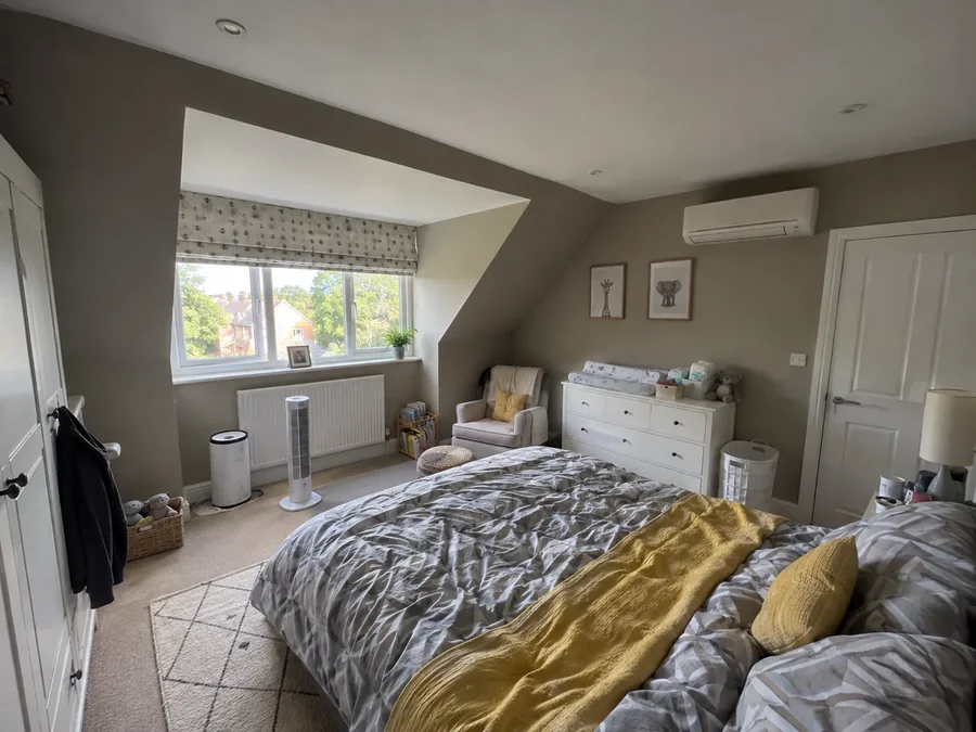 Attic bedroom under a pitched ceiling with the air conditioning fitted