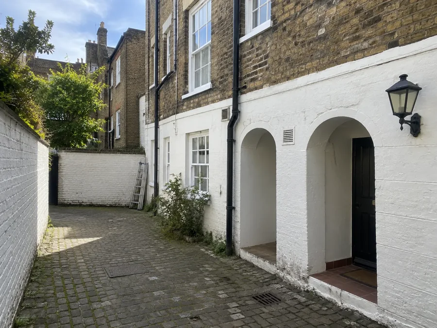 Arched passage through to a courtyard between painted houses