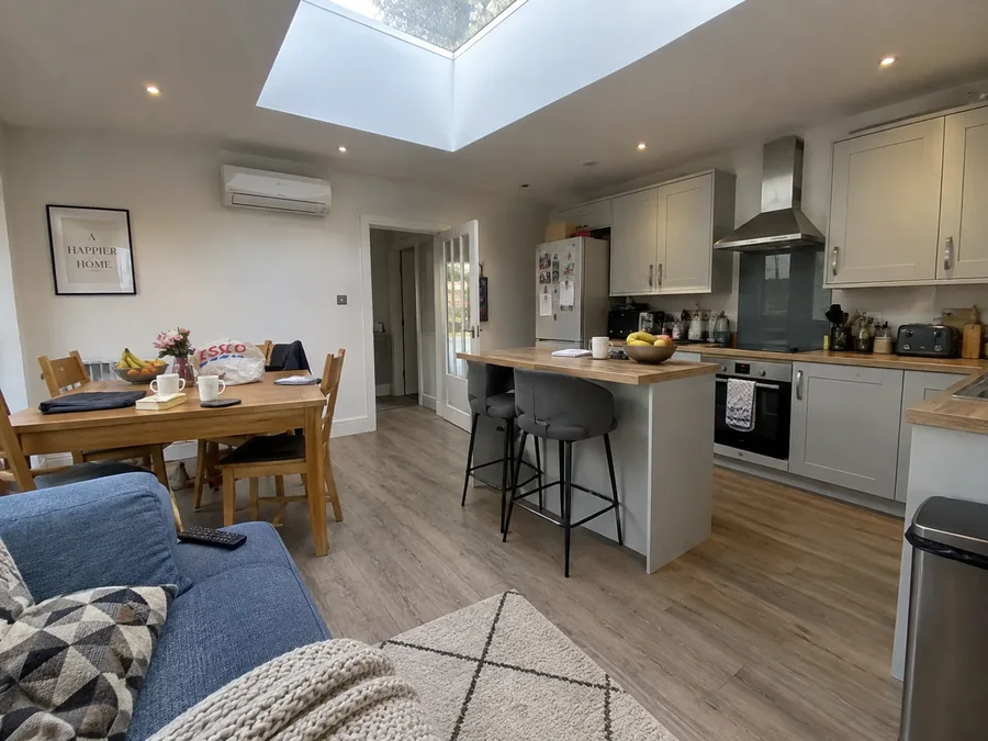Kitchen and dining room under a skylight with the air conditioning fitted