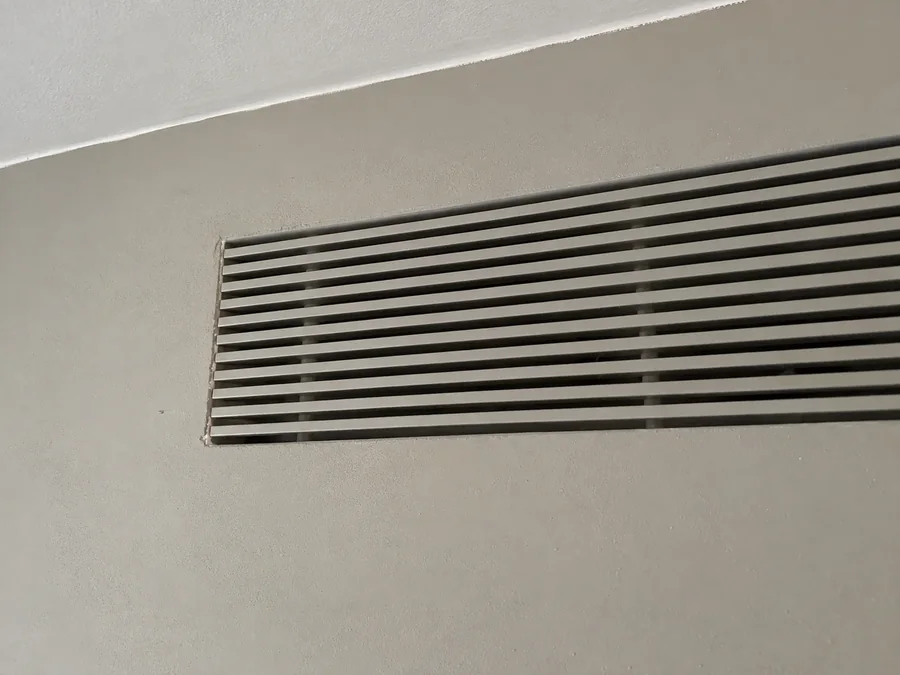 Close-up of a slim linear grille set flush into the plaster