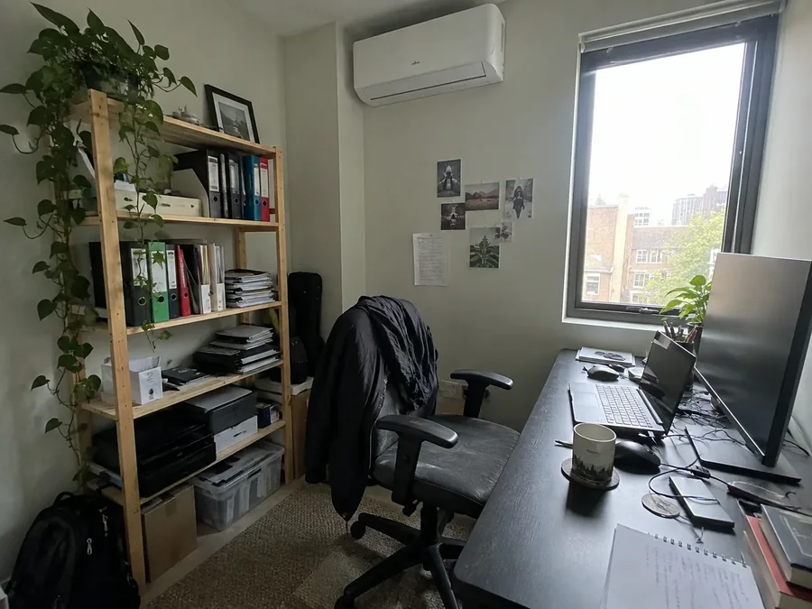 Home office with a desk at the window and the air conditioning fitted