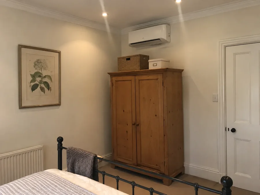 Guest room with a pine wardrobe, unit high on the wall above it