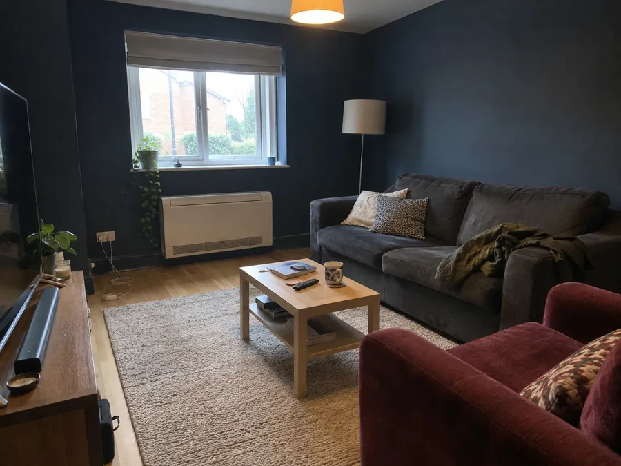Navy sitting room with a low-level unit fitted under the window